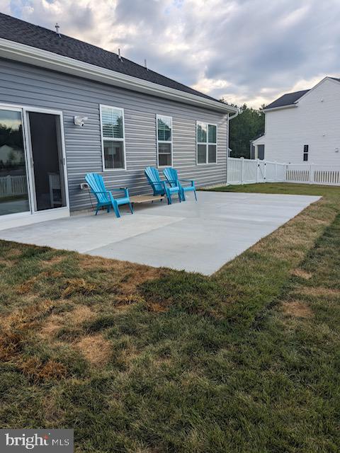 back of property with a patio area and a lawn