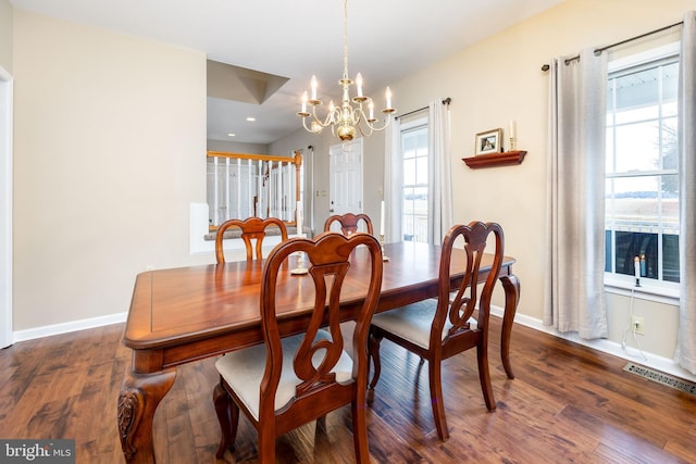 dining space with dark hardwood / wood-style flooring and a notable chandelier