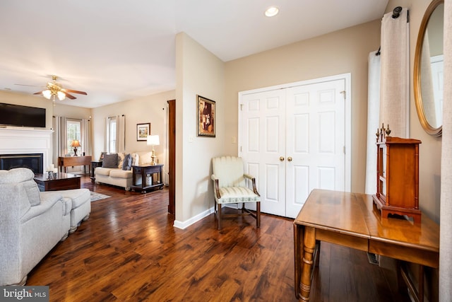 living room with dark wood-type flooring and ceiling fan