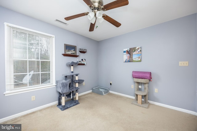 miscellaneous room with ceiling fan and light carpet