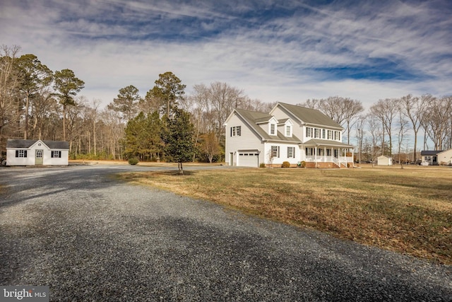 view of front of house featuring a garage, a front yard, and covered porch