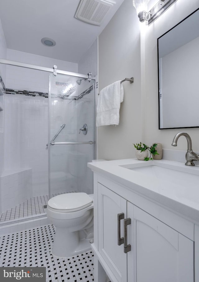 bathroom featuring tile patterned floors, visible vents, toilet, a shower stall, and vanity