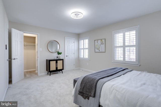 bedroom with light colored carpet and baseboards