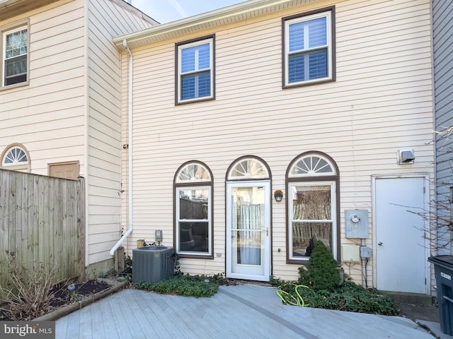 rear view of property with central air condition unit, a deck, and fence