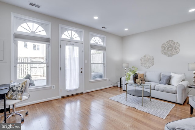 living area with visible vents, recessed lighting, and wood finished floors