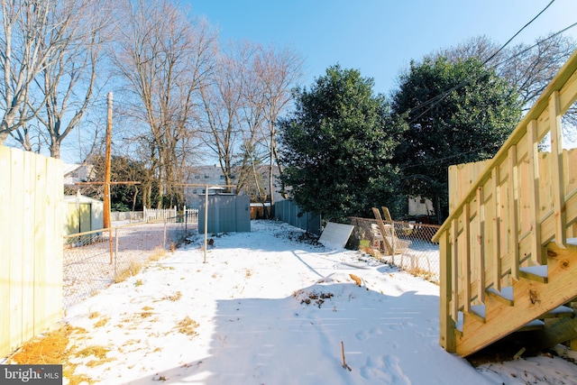 snowy yard with a storage shed