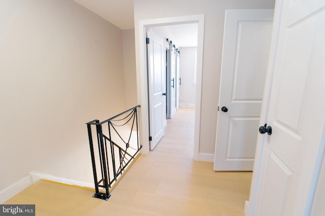 hallway with light hardwood / wood-style floors