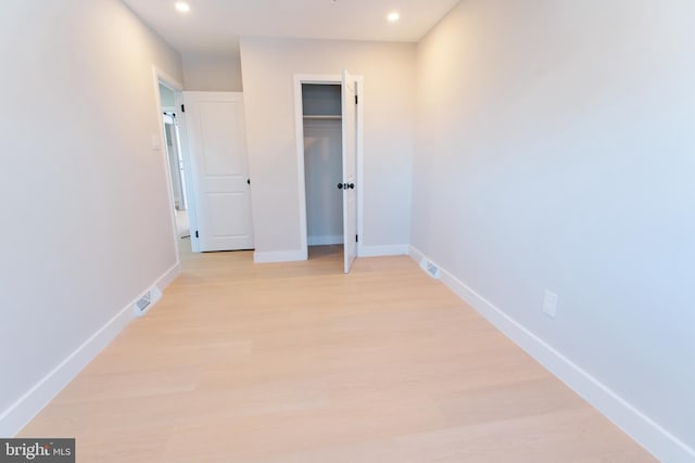 unfurnished bedroom featuring a closet and light hardwood / wood-style flooring