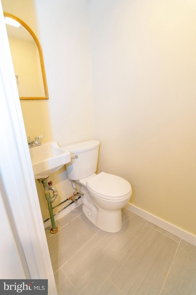 bathroom with toilet and tile patterned flooring