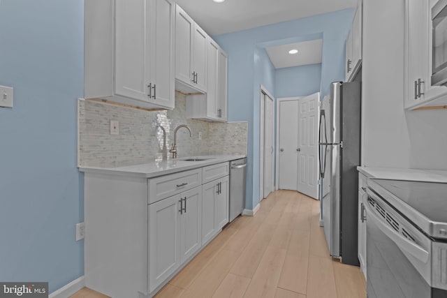 kitchen featuring white cabinets, stainless steel appliances, tasteful backsplash, and sink