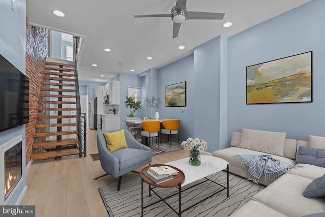 living room featuring ceiling fan and light hardwood / wood-style floors