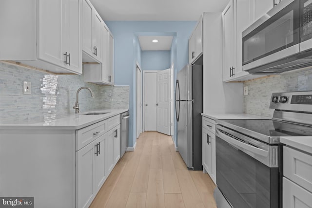 kitchen with sink, white cabinets, appliances with stainless steel finishes, and tasteful backsplash