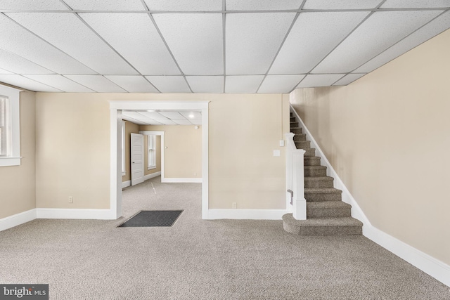 basement featuring carpet floors and a paneled ceiling