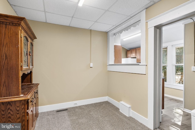 interior space featuring a drop ceiling and carpet flooring