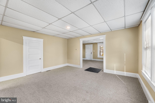 carpeted spare room featuring a paneled ceiling