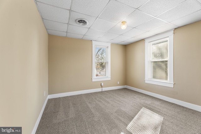 unfurnished room featuring a paneled ceiling and carpet flooring