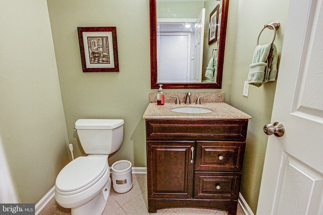 bathroom featuring baseboards, toilet, vanity, and tile patterned flooring