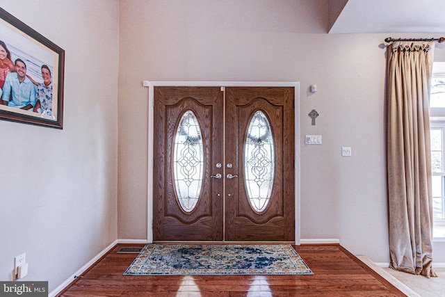 entrance foyer with hardwood / wood-style flooring, plenty of natural light, and baseboards