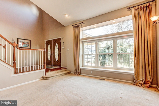 foyer featuring stairs, carpet, visible vents, and baseboards