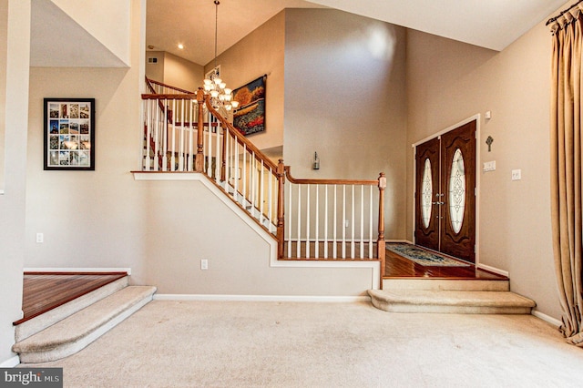 foyer entrance with stairway, carpet flooring, baseboards, and an inviting chandelier