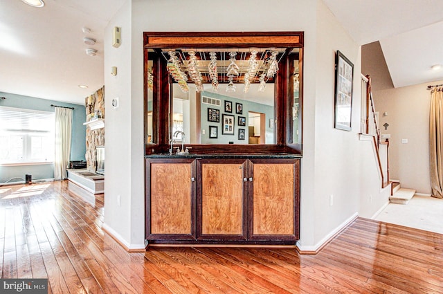 interior space with hardwood / wood-style flooring, stairway, baseboards, and a sink