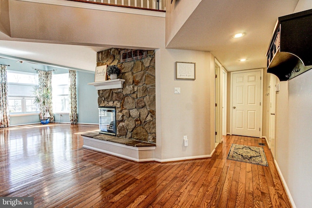 corridor featuring baseboards and hardwood / wood-style flooring