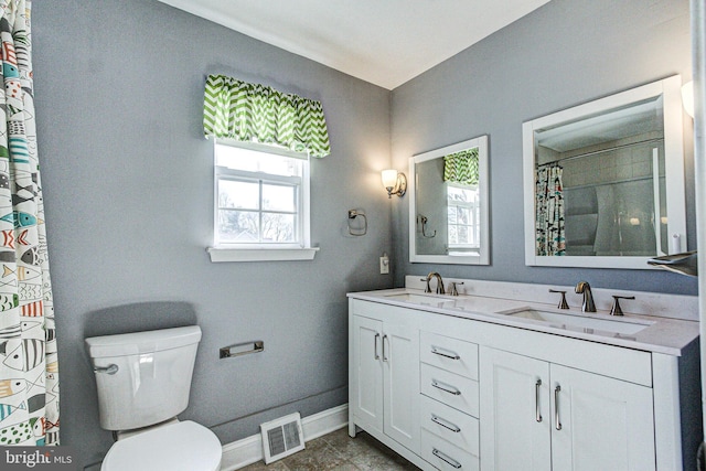 bathroom featuring a sink, visible vents, baseboards, and toilet