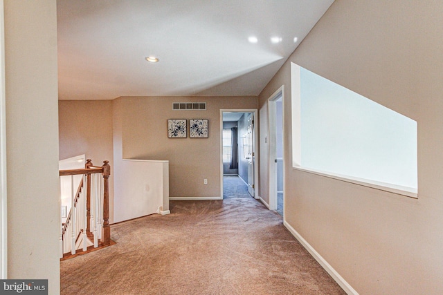 hall featuring an upstairs landing, visible vents, carpet floors, and baseboards