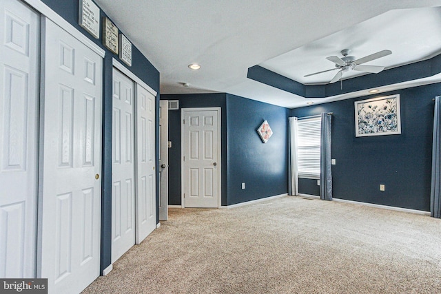 unfurnished bedroom featuring carpet flooring, baseboards, and multiple closets