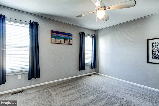 unfurnished room featuring carpet flooring, ceiling fan, baseboards, and visible vents