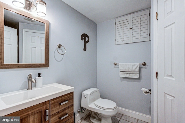 bathroom featuring vanity, toilet, visible vents, and baseboards