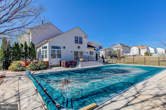 view of pool with fence, a fenced in pool, a residential view, and a hot tub