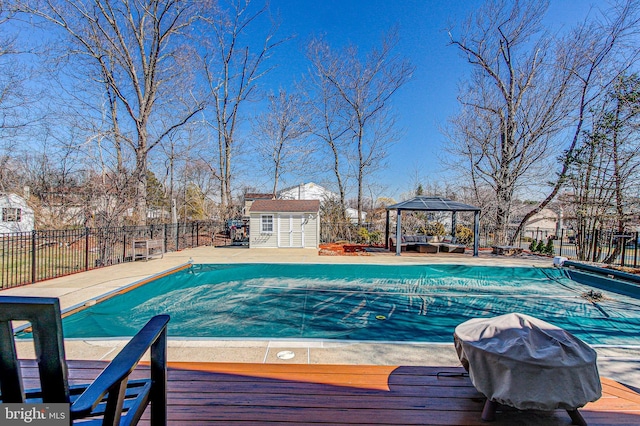 view of swimming pool featuring a gazebo, area for grilling, fence, and a fenced in pool