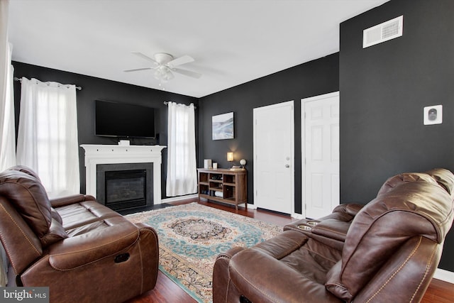 living room with ceiling fan and dark hardwood / wood-style flooring