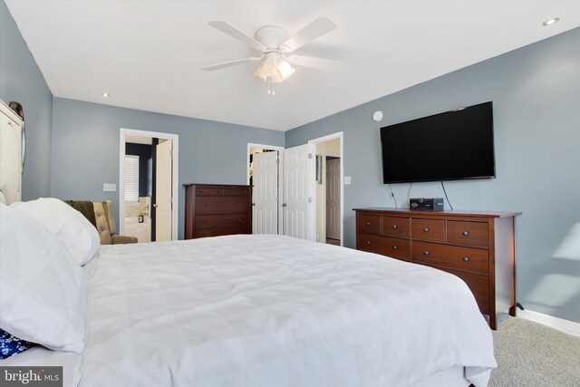 bedroom featuring connected bathroom, ceiling fan, and carpet flooring