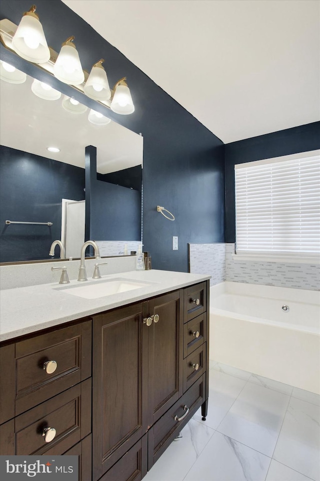 bathroom featuring vanity and a washtub