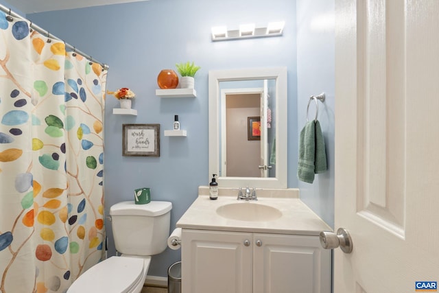 bathroom featuring vanity, toilet, and walk in shower