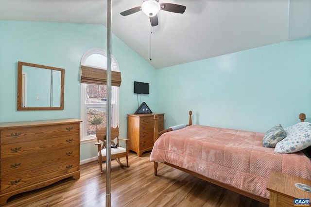 bedroom featuring ceiling fan, light hardwood / wood-style floors, and lofted ceiling