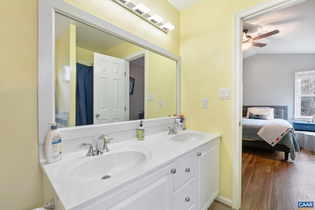 bathroom with ceiling fan, wood-type flooring, vanity, and vaulted ceiling