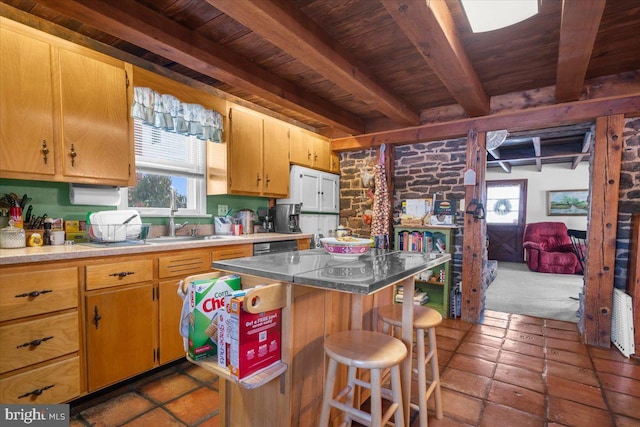 kitchen with a breakfast bar, sink, wood ceiling, a center island, and beam ceiling