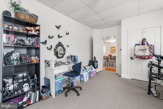 carpeted office space with a paneled ceiling