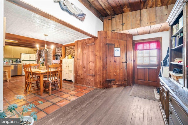 dining area with an inviting chandelier, hardwood / wood-style floors, and wood walls