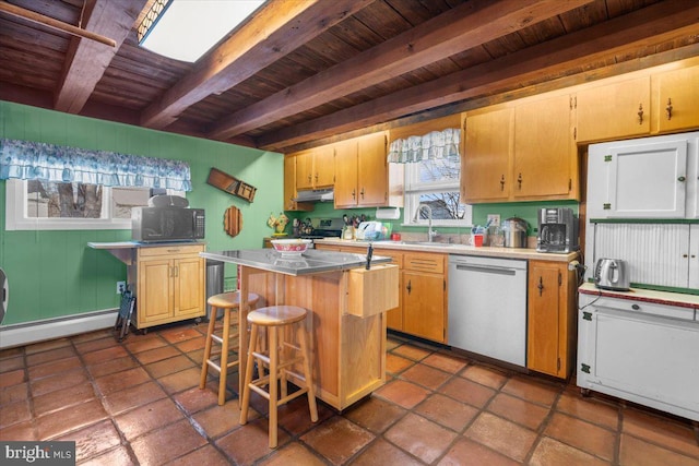 kitchen featuring stainless steel appliances, beam ceiling, a kitchen island, and plenty of natural light