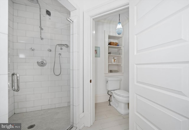 bathroom featuring tile patterned flooring, a shower with shower door, and toilet