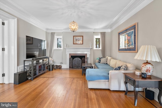 living room with a wealth of natural light, ornamental molding, and wood-type flooring