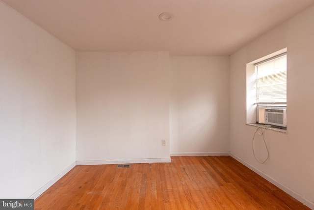 spare room featuring cooling unit and light wood-type flooring