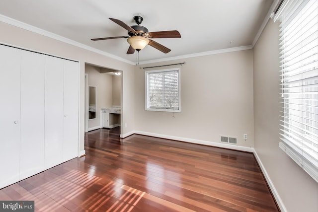 unfurnished bedroom with dark hardwood / wood-style flooring, ornamental molding, a closet, and ceiling fan