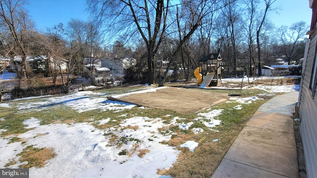 yard layered in snow with a playground