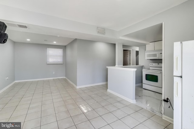 kitchen with white cabinetry, light tile patterned floors, and white appliances