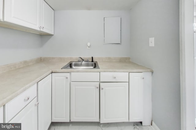 kitchen featuring white cabinetry and sink